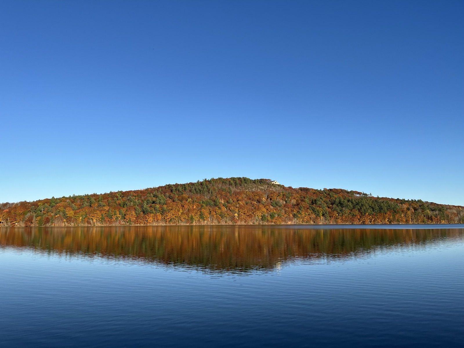 Autumn foliage reflected in a still lake in Maine