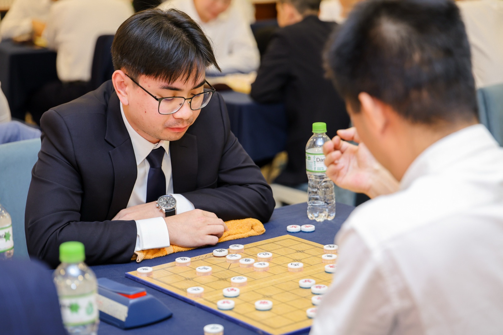 Thanh Ly mid-match at the Vin33 Chinese Chess Tournament, facing an opponent across the board