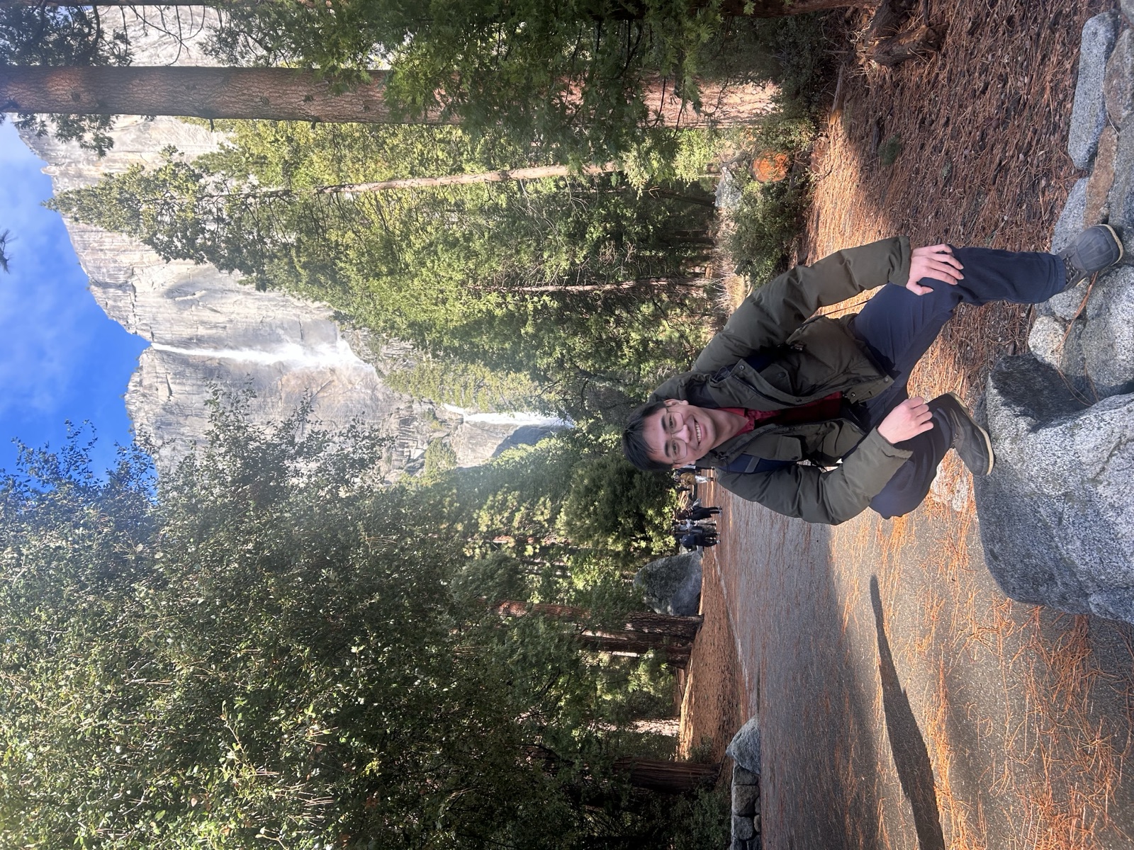 Standing on a boulder near a waterfall in Yosemite Valley